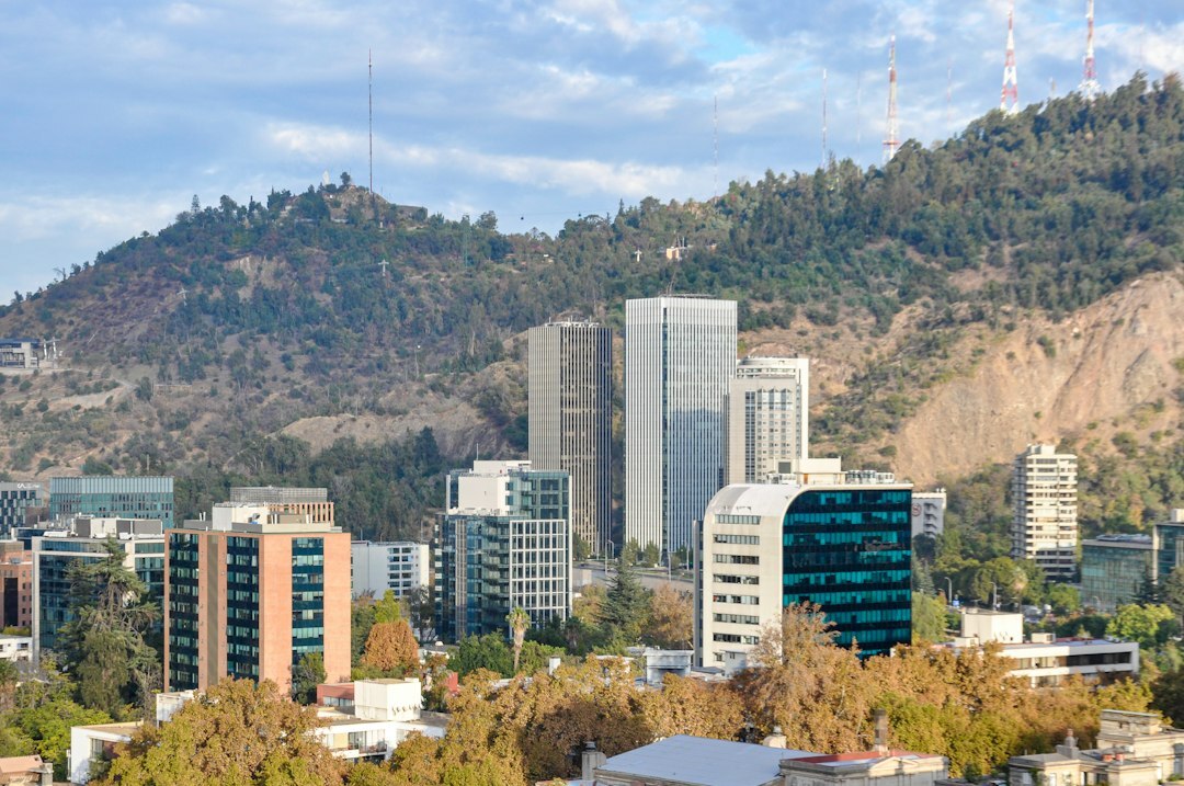 Modern glass skyscrapers in downtown Santiago with mountains behind